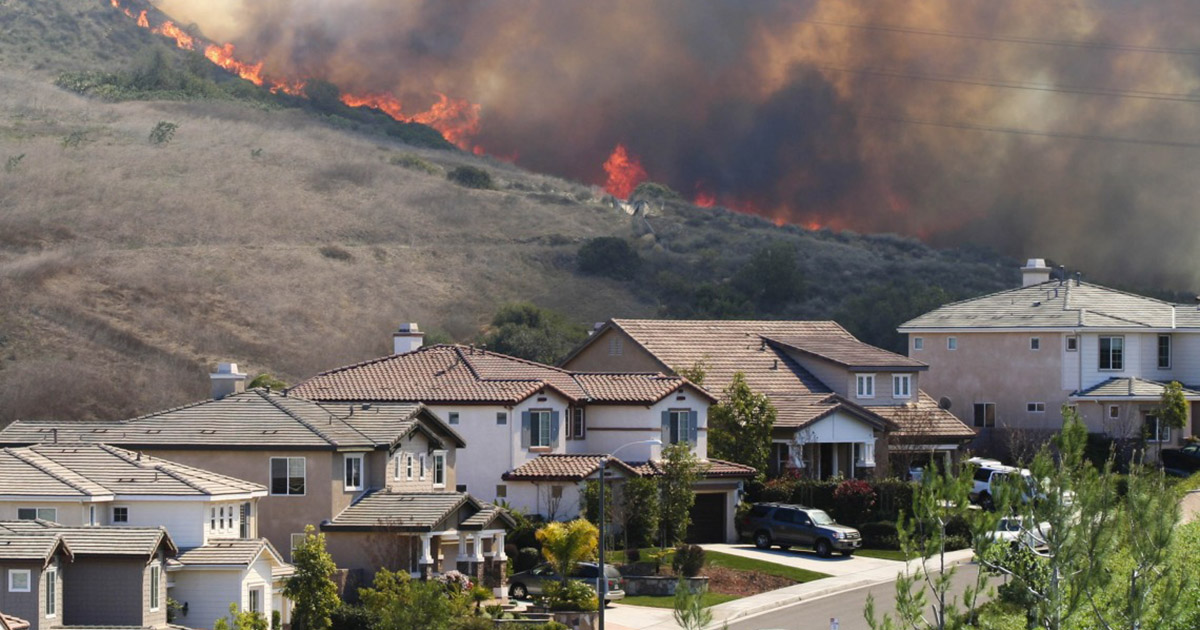Wildfire in the background of a neighborhood