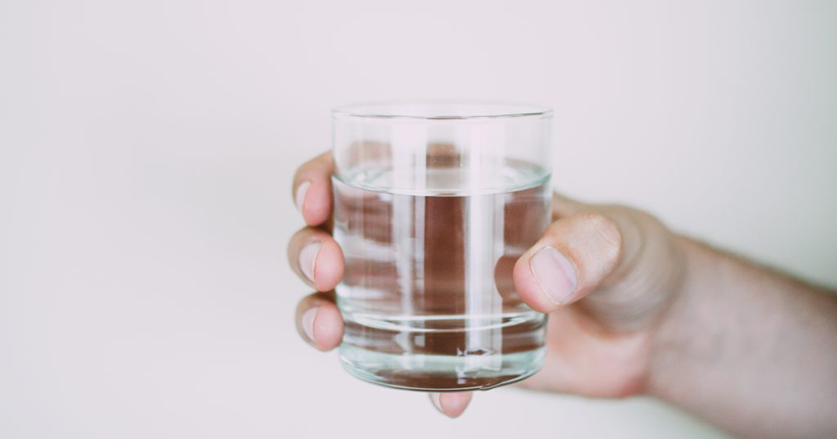 person holding a glass of water