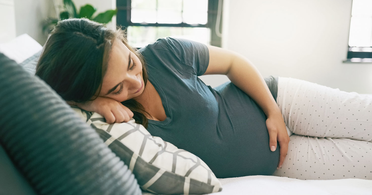 pregnant woman sleeping on a bed