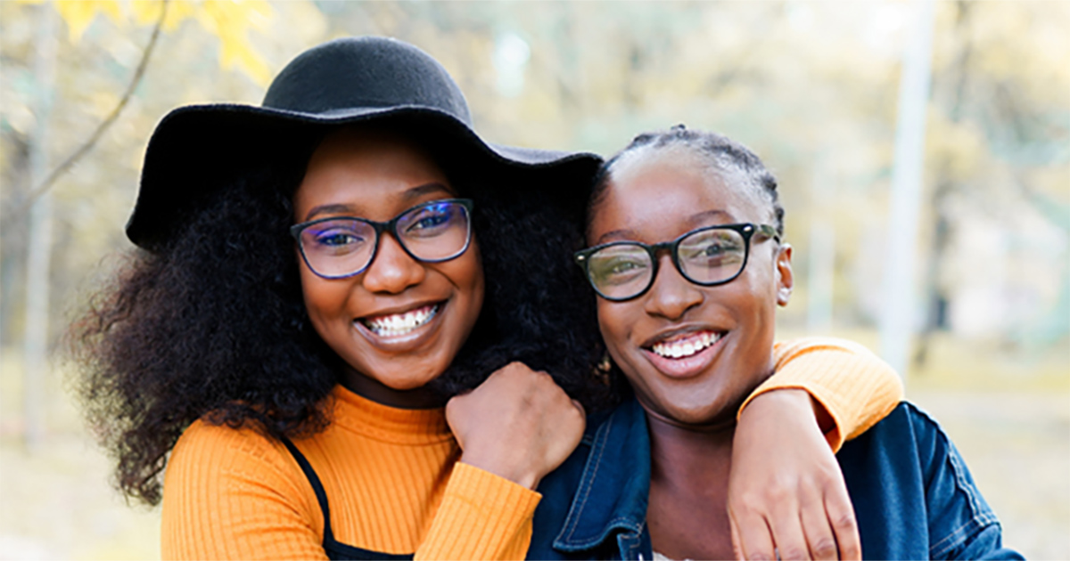 Two young Black women smiling and posing for a candid
