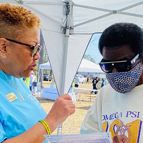 An NC Coastal Federation Board member speaks with a community member about fishing consumption advisories. (Photo courtesy of Duke SRP Center)