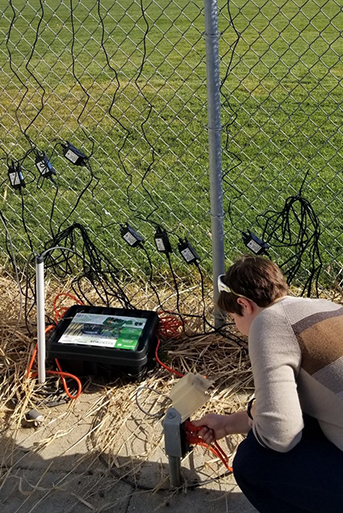Team member setting up Purple Air sensor outside