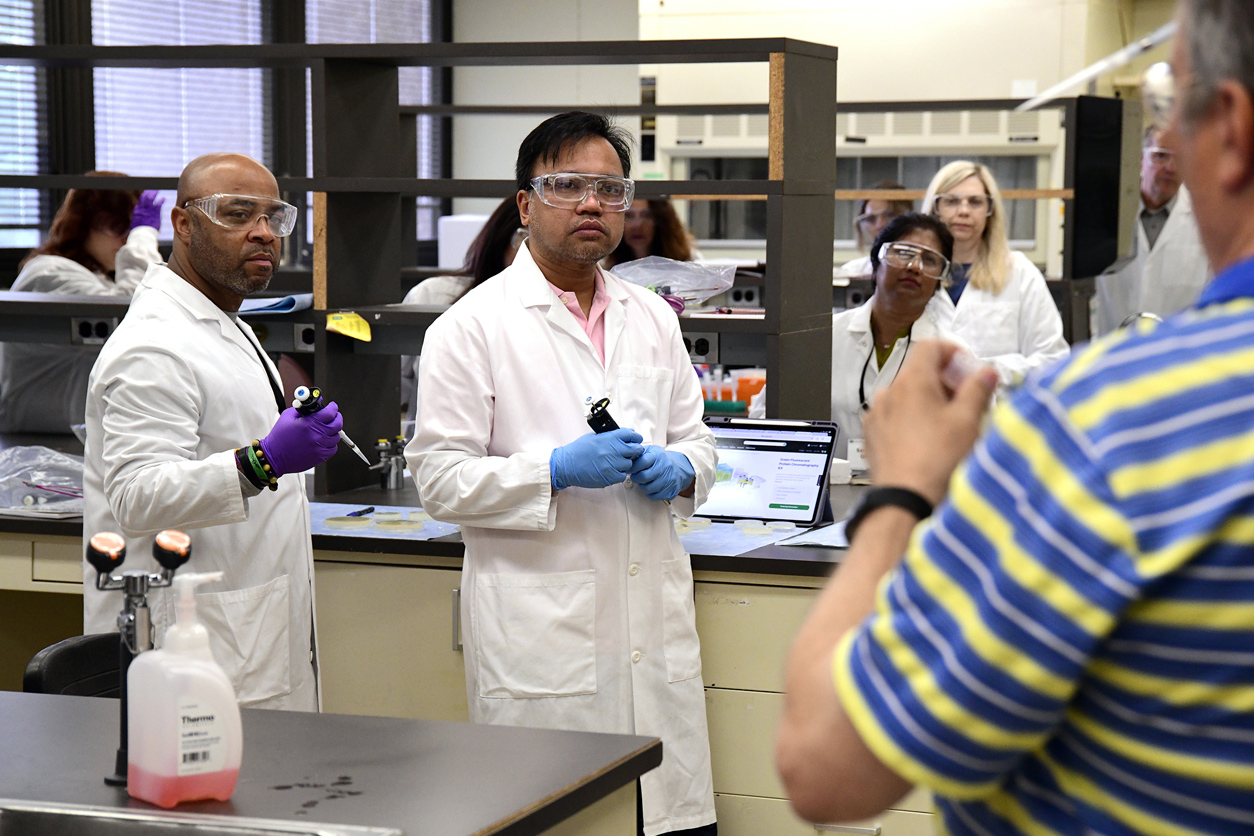 scientists listening to instruction in a lab