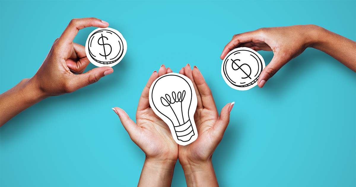 hands holding light bulb paper cut outs 