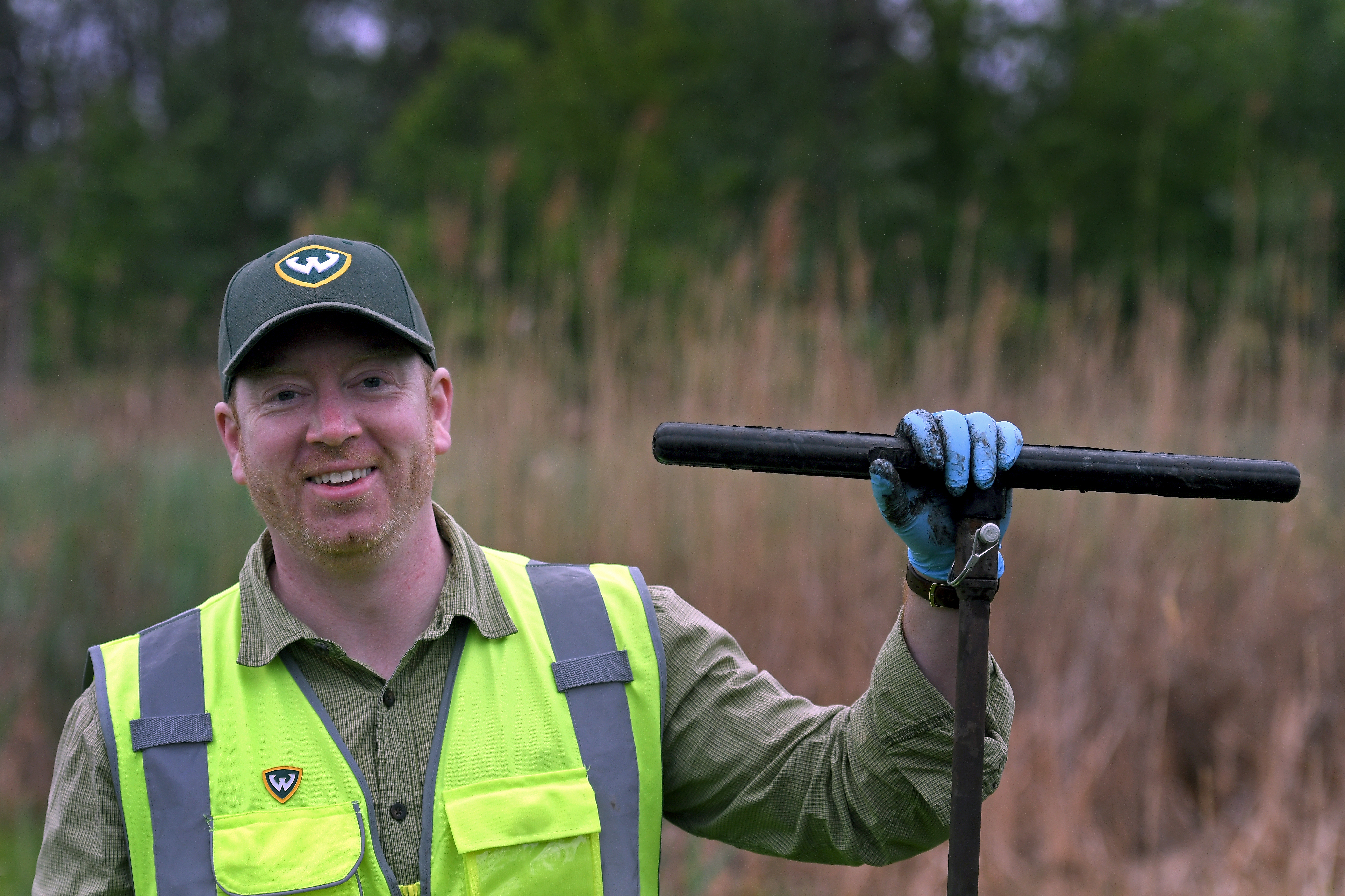 Brendan O'Leary standing in a field with a reflective vest on