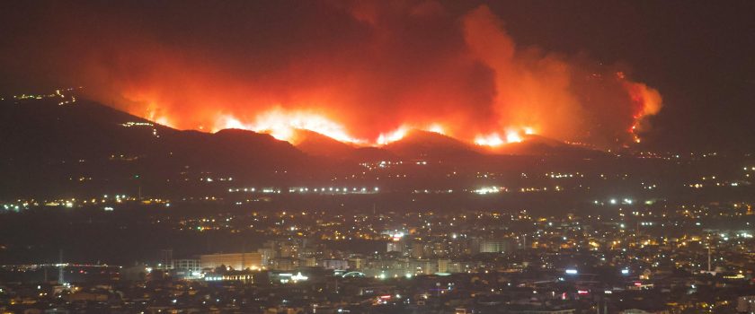 A wildfire on a hillside above homes