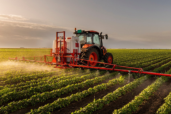 Farm tractor spraying crops with herbicides