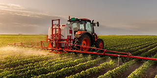 Farm tractor spraying crops with herbicides
