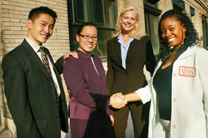 Four community people shaking hands and smiling