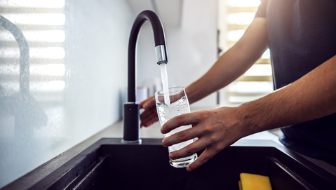 Filling a glass of water in a sink
