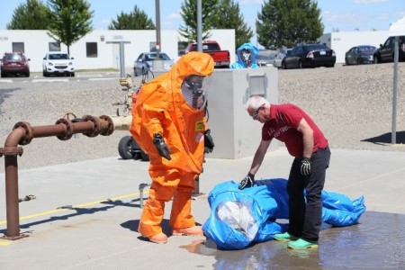 Worker in HAZMAT suit receiving training