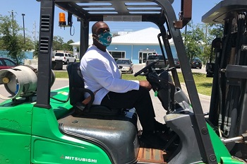 Worker driving forklift