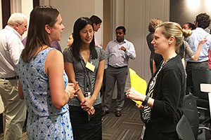 Kirsten Verhein, Ph.D., left, and Gabor, center, talked with an INC Research participant during the informal networking portion of the July 7 site visit