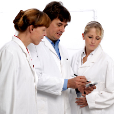 three colleagues in white coats observing