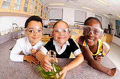 Children in a science lab wearing protective eye gear.