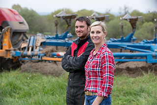 farm couple in front of tractor