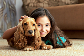 young girl lying on the floor with a small dog