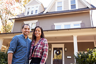 Man and woman standing in front of a house