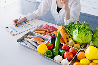 variedad de verduras y persona tomando notas