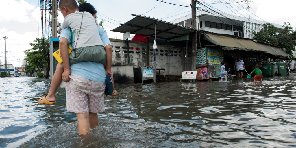 man carrying boy in a flood