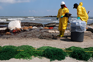 workers and firefighters cleaning up oil spill