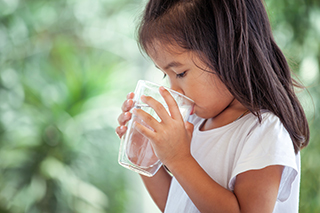 girl drinking water from glass