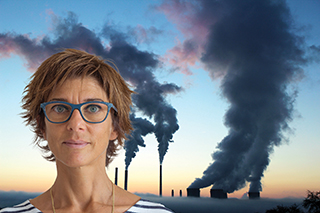 woman standing in front of a factory emitting smoke