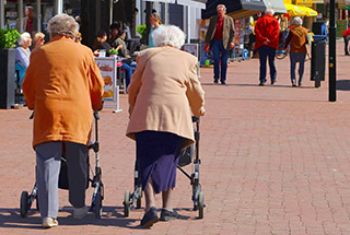 two elderly ladies walking in crowded city street