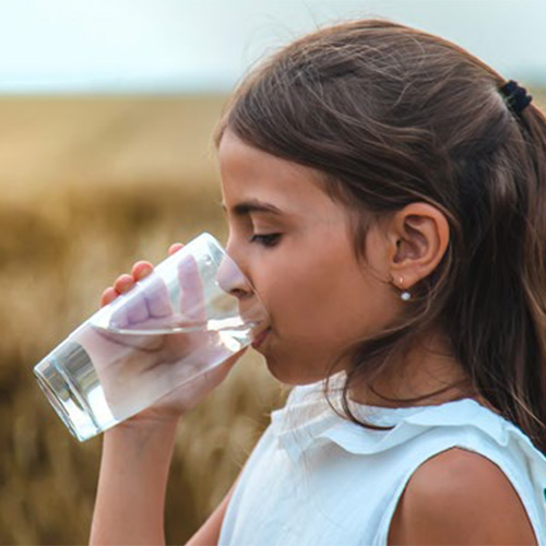child drinking a glass of water