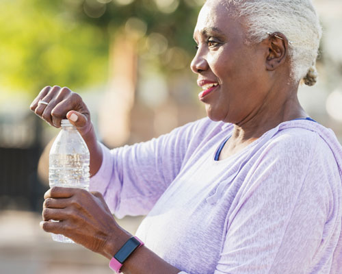 older woman opening bottled water