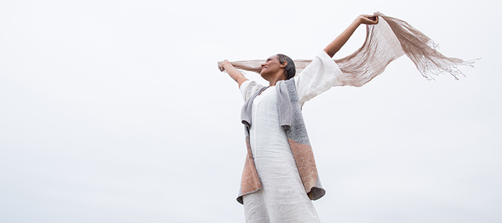 woman lifting scarf above her head