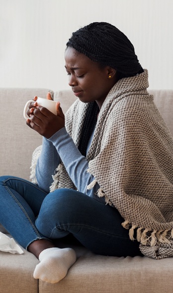 woman wrapped in a blanket holding a mug