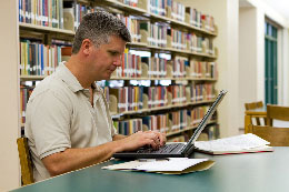 Man using a laptop in a library