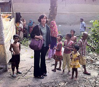 Yu Chen, Ph.D., standing with children around