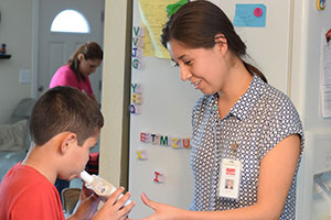 staff member coaches a patient during an asthma test