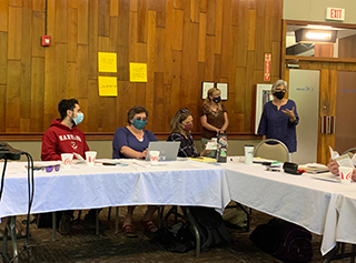 Betsy Taylor (far right) facilitates a discussion to derive foundational principles of this research partnership, while university and community partners contribute.