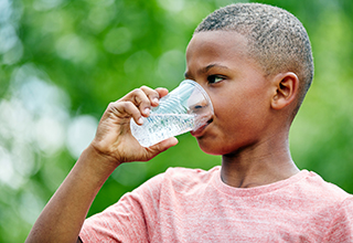 boy drinking a cup of water