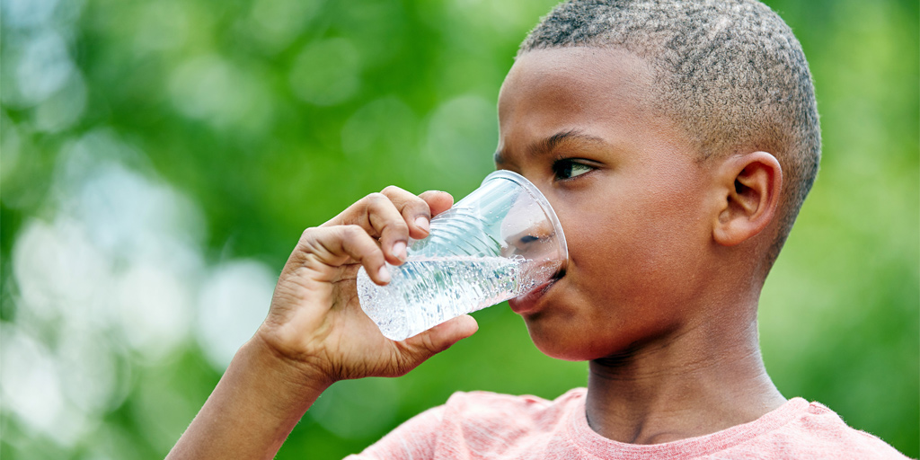 boy drinking a cup of water 