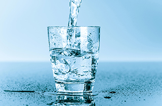 water pouring into a glass of water