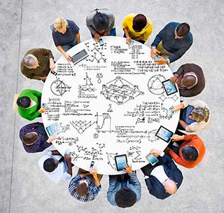 people seated at a circular table working on math problems