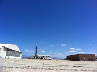 arid desert area with buildings and trucks