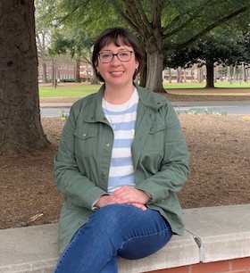 Anne M. Spuches sitting on a wall.