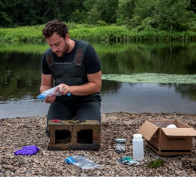 Matt Dunn working with sampling device along riverbed
