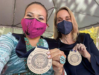 Karletta Chief and another woman proudly showcasing their awards