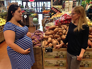 Curl, right, talks with a community member in a local market.