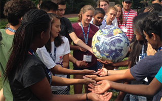 students passing and looking at an Earth ball while participating in Climate LEAP