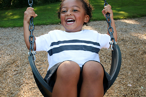young girl laughing on a swing