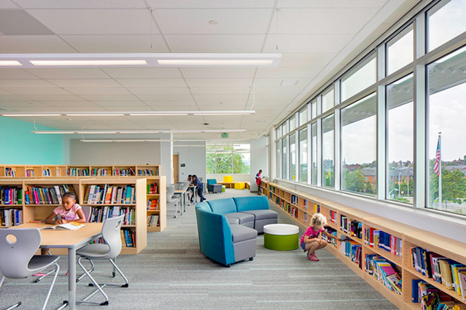 Inside view of a library with children reading and looking for books