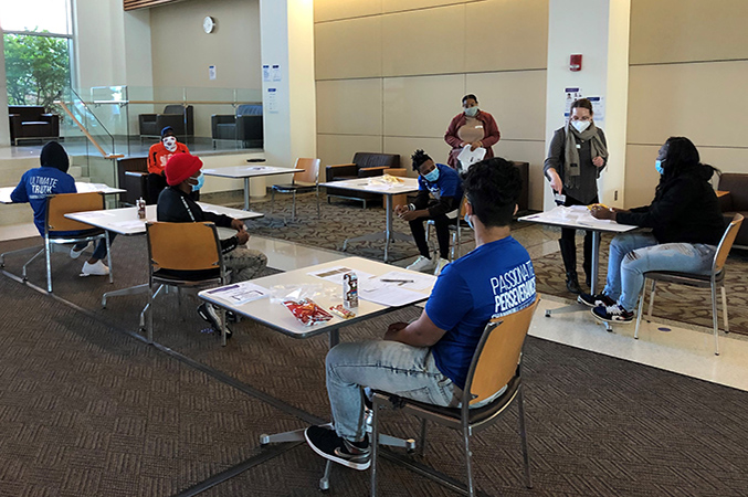 a group of people sitting at individual, socially distanced tables