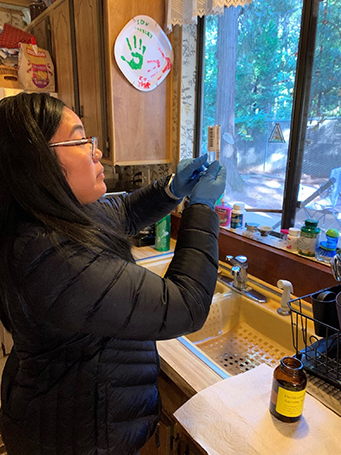 woman researcher holding and observing a vile at a kitchen sink